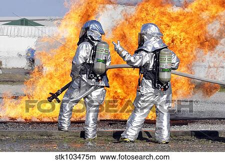 Picture - Firefighters battle a simulated fire.. Fotosearch