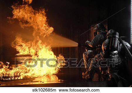 Picture - Firefighters extinguish a simulated battery fire.. Fotosearch