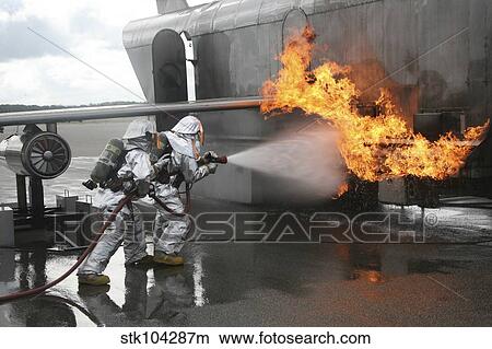 Firefighters extinguish an exterior fire during a training exercise. View Large Photo Image Picture - Firefighters extinguish an exterior fire during a training exercise.. Fotosearch
