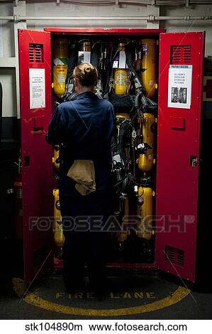 Fireman stows a self-contained breathing apparatus in a locker. View Large Photo Image Picture - Fireman stows a self-contained breathing apparatus in a locker.. Fotosearch