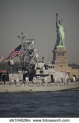 Picture - Fleet week vessels pass by the Statue of Liberty.. Fotosearch
