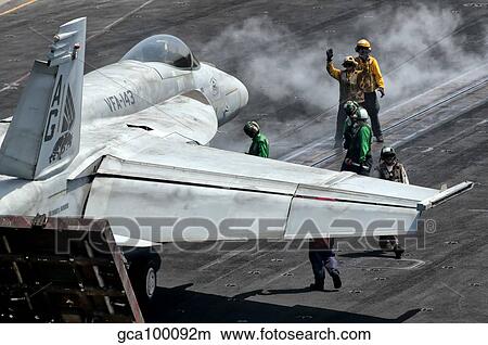 Flight deck crew position an F/A-18E Super Hornet into launch position aboard USS Eisenhower. View Large Photo Image Picture - Flight deck crew position an F/A-18E Super Hornet into launch position aboard USS Eisenhower.. Fotosearch