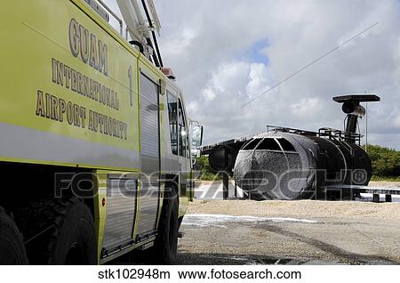 Picture - Guam's WONPAT Airport practices putting out a fire on the aircraft fire trainer.. Fotosearch