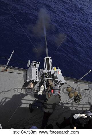 Gunner fires a Mark 38 machine gun aboard USS Frank Cable. View Large Photo Image Picture - Gunner fires a Mark 38 machine gun aboard USS Frank Cable.. Fotosearch
