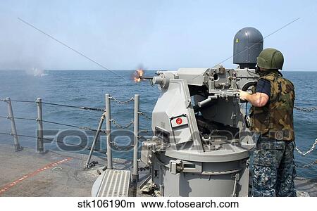 Gunner's Mate fires a 25mm chain gun aboard USS Cape St. George. View Large Photo Image Picture - Gunner's Mate fires a 25mm chain gun aboard USS Cape St. George.. Fotosearch