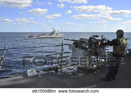 Gunner's Mate mans the MK-38 25mm machine gun aboard USS Porter. View Large Photo Image Picture - Gunner's Mate mans the MK-38 25mm machine gun aboard USS Porter.. Fotosearch