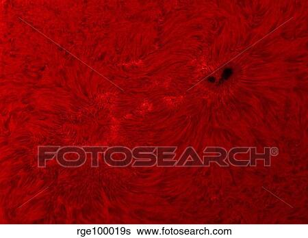 Stock Photograph - H-alpha Sun in red with sunspot.. Fotosearch