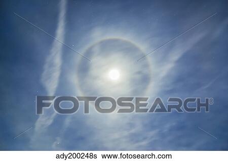 Halo around full moon in a sky of cirrus clouds and contrails. View Large Photo Image Stock Photograph - Halo around full moon in a sky of cirrus clouds and contrails.. Fotosearch