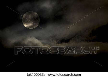 Stock Photograph - Harvest Moon through clouds.. Fotosearch