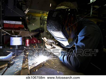 Picture - Hull Maintenance Technician strikes a welding rod.. Fotosearch