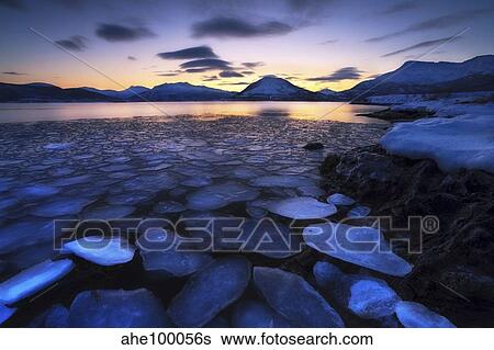 Ice flakes drifting against the sunset in Tjeldsundet strait, Troms County, Norway. View Large Photo Image Stock Photograph - Ice flakes drifting against the sunset in Tjeldsundet strait, Troms County, Norway.. Fotosearch