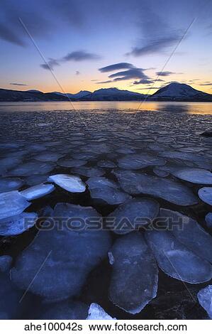 Stock Photograph - Ice flakes drifting towards the mountains on Tjeldoya Island, Norway.. Fotosearch