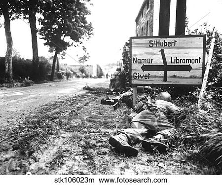 Picture - Infantrymen seek cover during a firefight in Libin, Belgium, during WWII.. Fotosearch