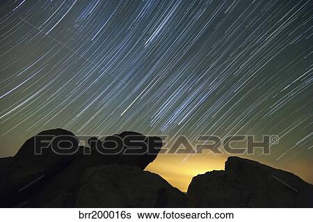 Light pollution illuminates the sky and star tails above large boulders. View Large Photo Image Stock Photograph - Light pollution illuminates the sky and star tails above large boulders.. Fotosearch