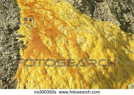 Stock Photograph - Liquid sulphur flow in Kawah Ijen Volcano Sulphur Mine, Java, Indonesia.. Fotosearch