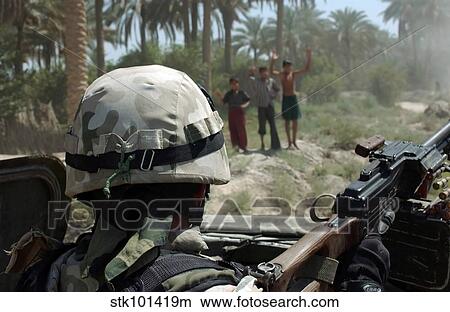 Local Iraqi children wave to a Polish Army Soldier manning a 7. 62 mm PK machine gun. View Large Photo Image Picture - Local Iraqi children wave to a Polish Army Soldier manning a 7. 62 mm PK machine gun.. Fotosearch