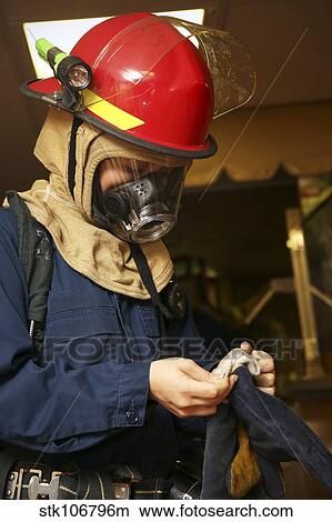 Machinery repairman puts on fire fighting gloves. View Large Photo Image Picture - Machinery repairman puts on fire fighting gloves.. Fotosearch