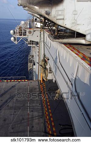 Marines and sailors fast-rope from the rear of a CH-46E Sea Knight. View Large Photo Image Picture - Marines and sailors fast-rope from the rear of a CH-46E Sea Knight.. Fotosearch