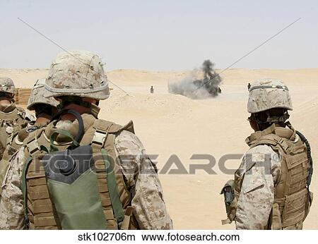 Marines and sailors look on as an explosion goes off. View Large Photo Image Picture - Marines and sailors look on as an explosion goes off.. Fotosearch