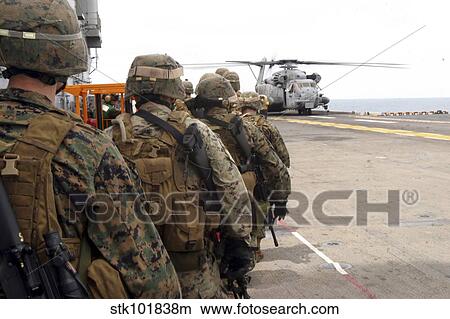 Marines and sailors progress to board a CH-53E Super Stallion. View Large Photo Image Picture - Marines and sailors progress to board a CH-53E Super Stallion.. Fotosearch