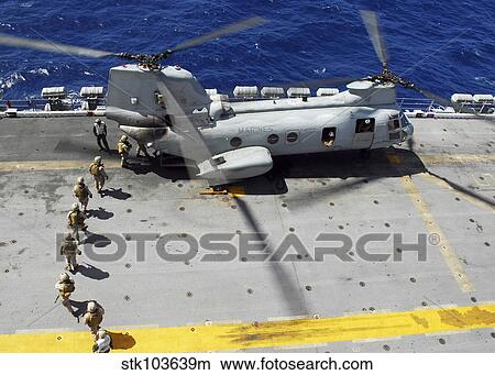 Marines board a CH-46E Sea Knight helicopter on the flight deck of USS Peleliu. View Large Photo Image Picture - Marines board a CH-46E Sea Knight helicopter on the flight deck of USS Peleliu.. Fotosearch