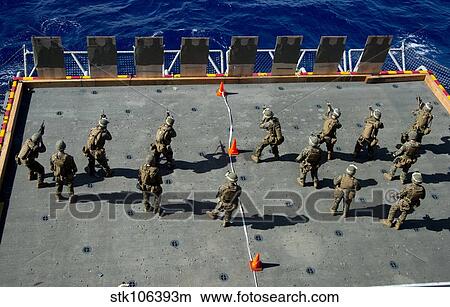 Marines fire rounds at targets on the aircraft elevator aboard USS Bonhomme Richard. View Large Photo Image Picture - Marines fire rounds at targets on the aircraft elevator aboard USS Bonhomme Richard.. Fotosearch