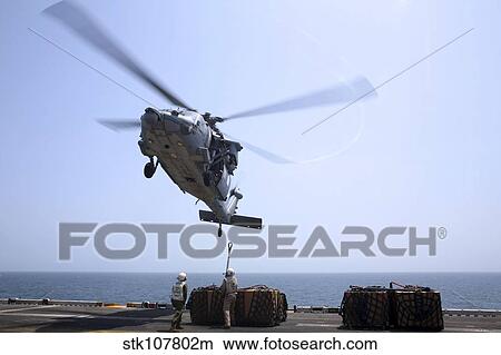 Marines hook cargo to an MH-60S Sea Hawk helicopter. View Large Photo Image Picture - Marines hook cargo to an MH-60S Sea Hawk helicopter.. Fotosearch