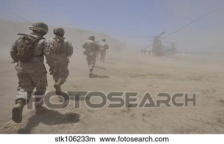 Marines move through a dust cloud toward a CH-46 Sea Knight. View Large Photo Image Picture - Marines move through a dust cloud toward a CH-46 Sea Knight.. Fotosearch