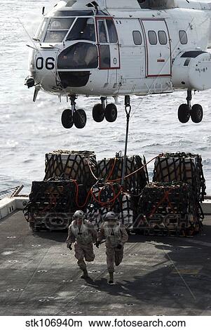 Marines run out from under an SA-330J Puma after hooking it to cargo. View Large Photo Image Picture - Marines run out from under an SA-330J Puma after hooking it to cargo.. Fotosearch