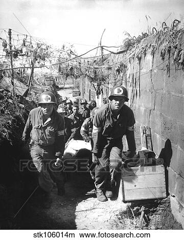 Medics remove a casualty from the battle field to an aid station. View Large Photo Image Picture - Medics remove a casualty from the battle field to an aid station.. Fotosearch