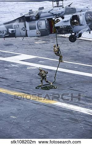 Members conduct a fast roping exercise on the flight deck of USS Carl Vinson. View Large Photo Image Picture - Members conduct a fast roping exercise on the flight deck of USS Carl Vinson.. Fotosearch