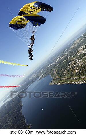 Members of the U. S. Navy Parachute Team, the Leap Frogs, perform a bi-plane with their parachutes above Seattle. View Large Photo Image Picture - Members of the U. S. Navy Parachute Team, the Leap Frogs, perform a bi-plane with their parachutes above Seattle.. Fotosearch