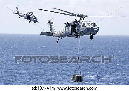 MH-60S Sea Hawk helicopters conduct a vertical replenishment. View Large Photo Image Picture - MH-60S Sea Hawk helicopters conduct a vertical replenishment.. Fotosearch