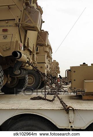 Military vehicles are locked down on semi trucks. View Large Photo Image Picture - Military vehicles are locked down on semi trucks.. Fotosearch