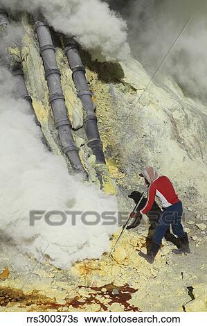 Miner breaking up sulphur deposits at Kawah Ijen Volcano, Java, Indonesia. View Large Photo Image Stock Photograph - Miner breaking up sulphur deposits at Kawah Ijen Volcano, Java, Indonesia.. Fotosearch
