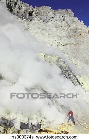 Miner breaking up sulphur deposits at Kawah Ijen Volcano, Java, Indonesia. View Large Photo Image Stock Photograph - Miner breaking up sulphur deposits at Kawah Ijen Volcano, Java, Indonesia.. Fotosearch