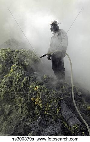 Stock Photograph - Miner cooling condensation pipes, Kawah Ijen volcano, Java, Indonesia.. Fotosearch