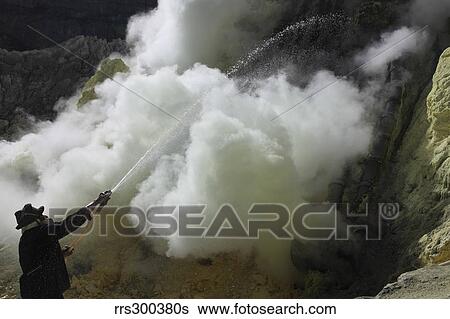 Stock Photograph - Miner cooling condensation pipes, Kawah Ijen volcano, Java, Indonesia.. Fotosearch