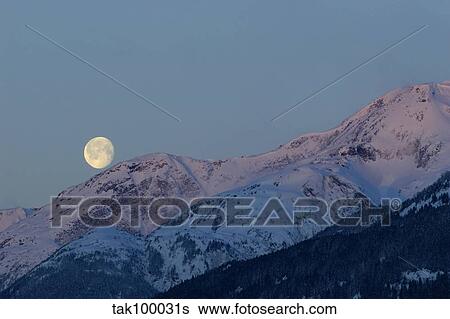 Stock Photograph - Moon and Alpenglow.. Fotosearch