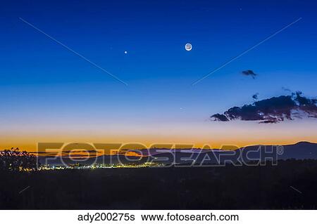 Stock Photograph - Moon, Mercury & Venus conjunction above Silver City, New Mexico.. Fotosearch