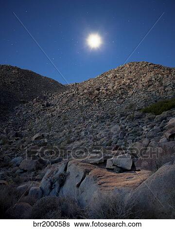 Stock Photograph - Moonlight illuminates the rugged terrain of Bow Willow Canyon, California.. Fotosearch