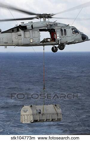 n MH-60S Sea Hawk en route with a shipment of supplies during a vertical replenishment at sea. View Large Photo Image Picture - n MH-60S Sea Hawk en route with a shipment of supplies during a vertical replenishment at sea.. Fotosearch