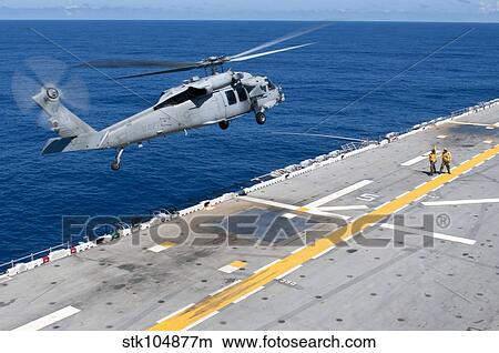 n MH-60S Sea Hawk helicopter lifts off the flight deck of USS Essex. View Large Photo Image Picture - n MH-60S Sea Hawk helicopter lifts off the flight deck of USS Essex.. Fotosearch