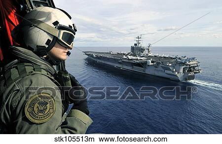 Naval Air Crewman conducts a visual patrol out of an SH-60F Sea Hawk. View Large Photo Image Picture - Naval Air Crewman conducts a visual patrol out of an SH-60F Sea Hawk.. Fotosearch