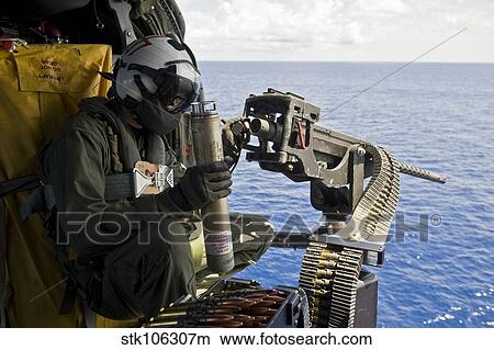 Naval Aircrewman manning a. 50 caliber machine gun aboard a MH-60 Seahawk. View Large Photo Image Picture - Naval Aircrewman manning a. 50 caliber machine gun aboard a MH-60 Seahawk.. Fotosearch