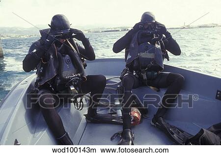 Navy SEALs combat swimmers in a utility boat adjust their dive masks. View Large Photo Image Picture - Navy SEALs combat swimmers in a utility boat adjust their dive masks.. Fotosearch