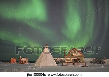 Stock Photograph - Northern Lights above village, Northwest Territories, Canada.. Fotosearch