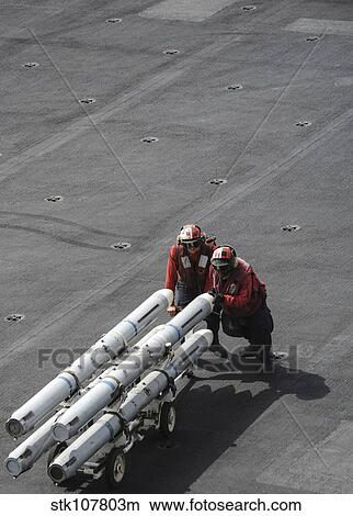 Ordnancemen push ordnance across the flight deck of USS Nimitz. View Large Photo Image Picture - Ordnancemen push ordnance across the flight deck of USS Nimitz.. Fotosearch