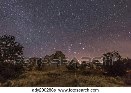 Stock Photograph - Orion rising at the City of Rocks State Park, New Mexico.. Fotosearch