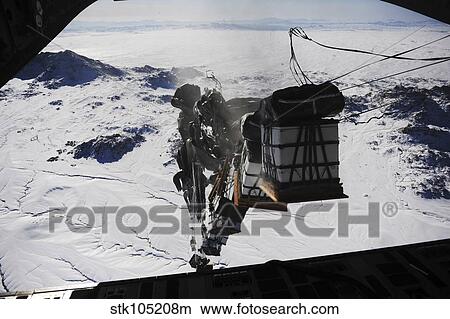 Pallets are released from a C-130 Hercules over Afghanistan. View Large Photo Image Picture - Pallets are released from a C-130 Hercules over Afghanistan.. Fotosearch